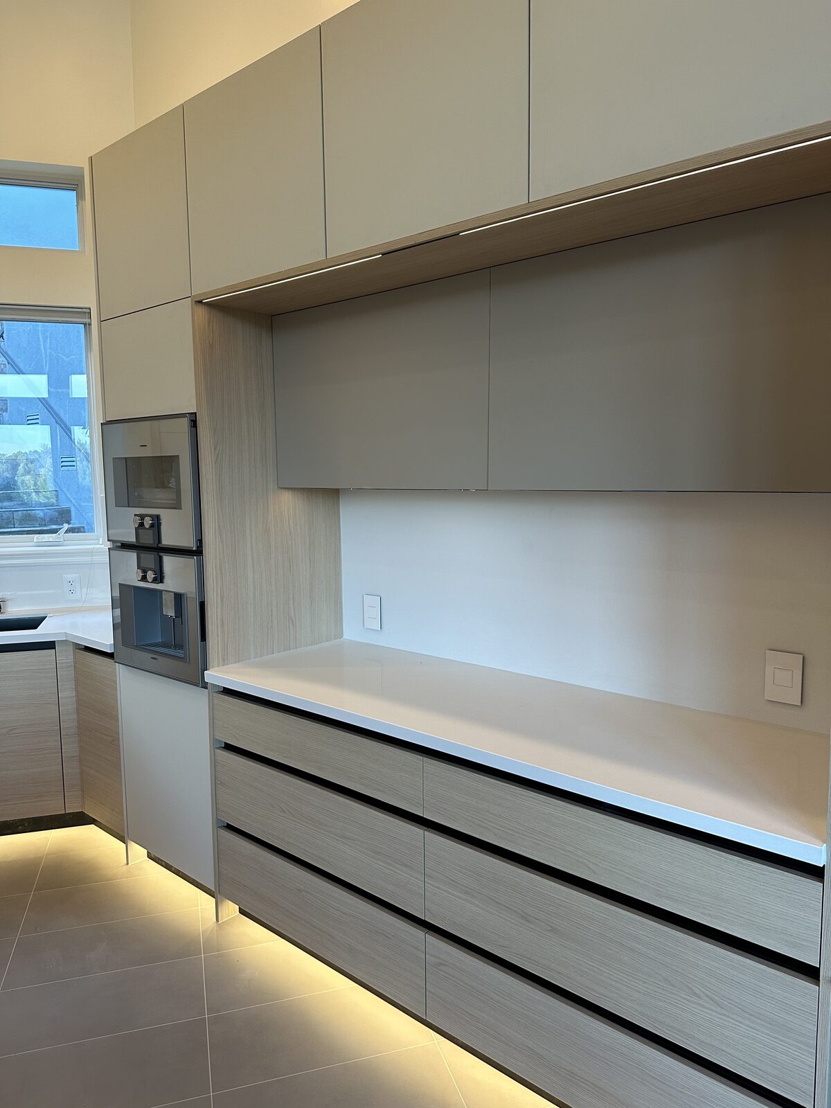 White oak kitchen with toekick lighting and espresso center — DodiHome