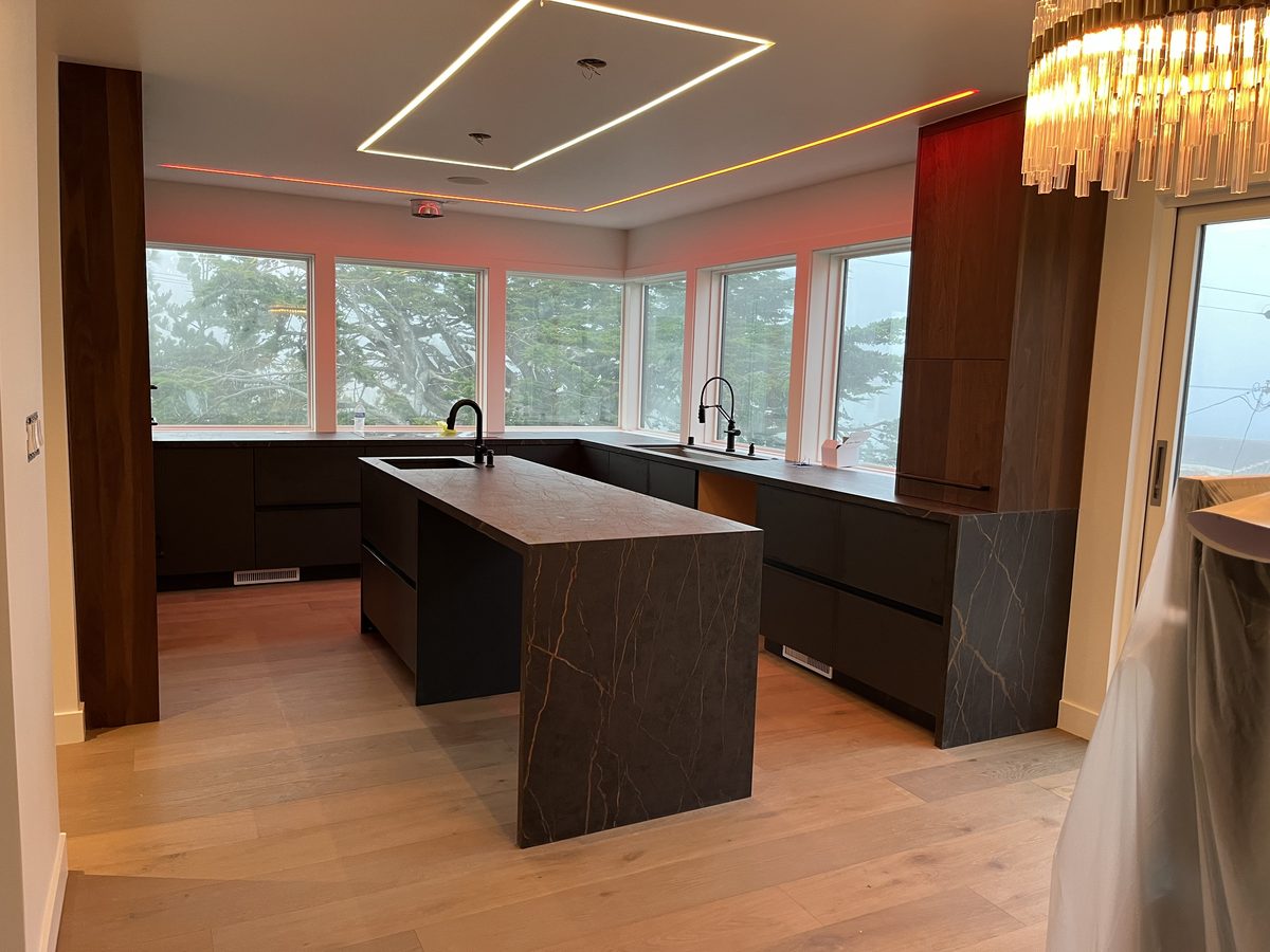 Second finished-room view of black island & walnut kitchen cabinetry and surrounding surfaces