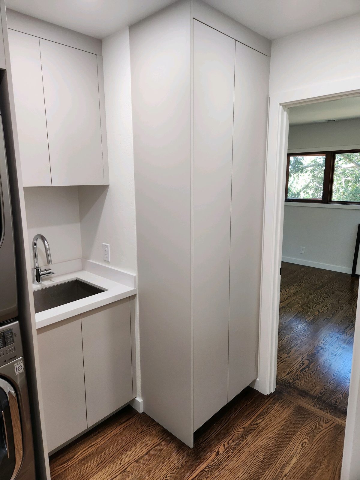 Second finished-room view of compact laundry cabinetry cabinetry and surrounding surfaces
