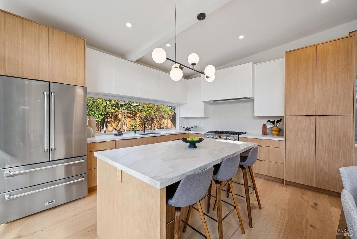 Third finished-room view of indoor-outdoor natural wood kitchen cabinetry and surrounding surfaces