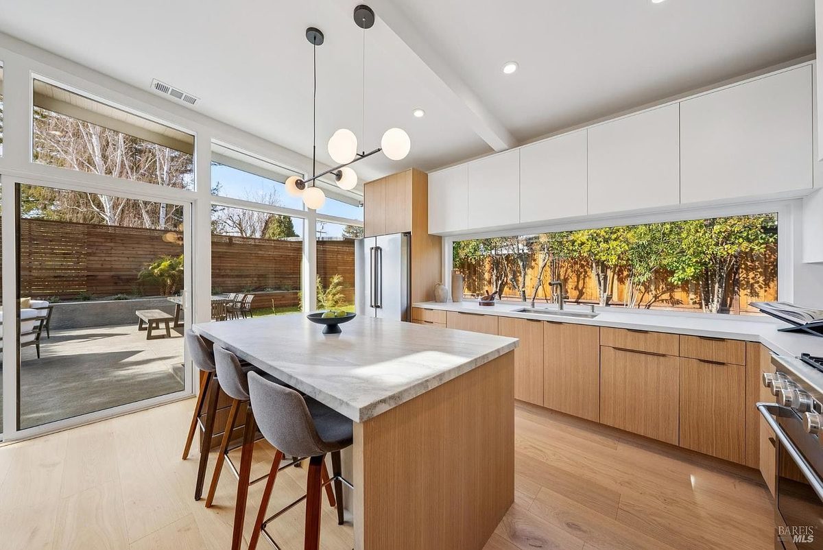Fourth finished-room view of indoor-outdoor natural wood kitchen cabinetry and surrounding surfaces