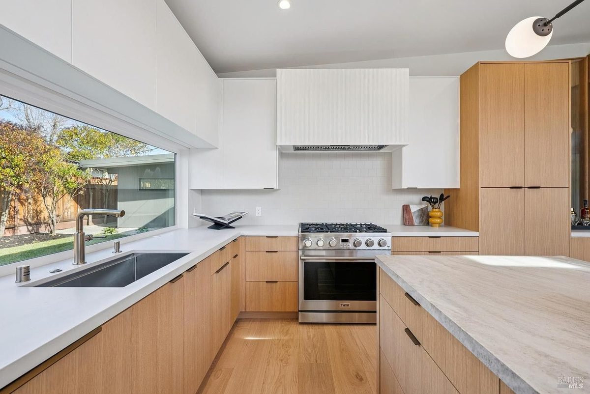 Fifth finished-room view of indoor-outdoor natural wood kitchen cabinetry and surrounding surfaces