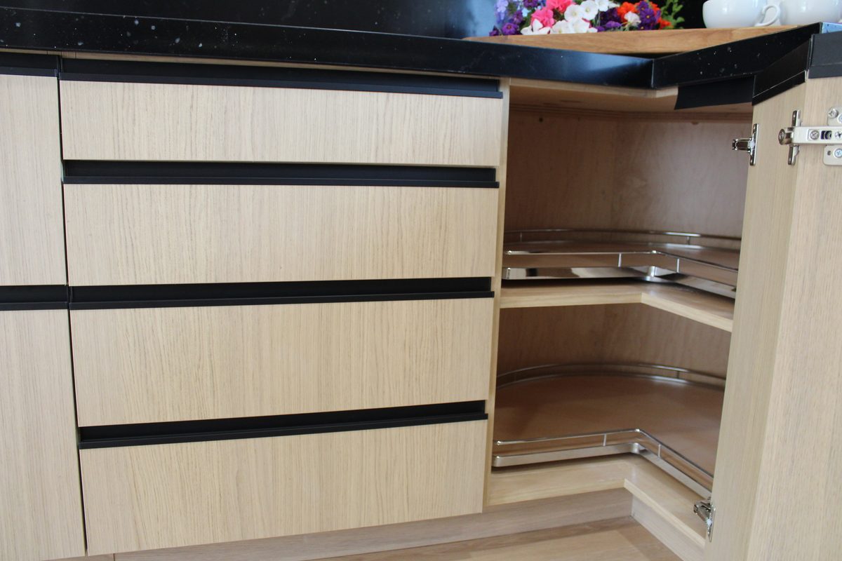 Corner lazy Susan shelving and drawer stack open in the light oak kitchen
