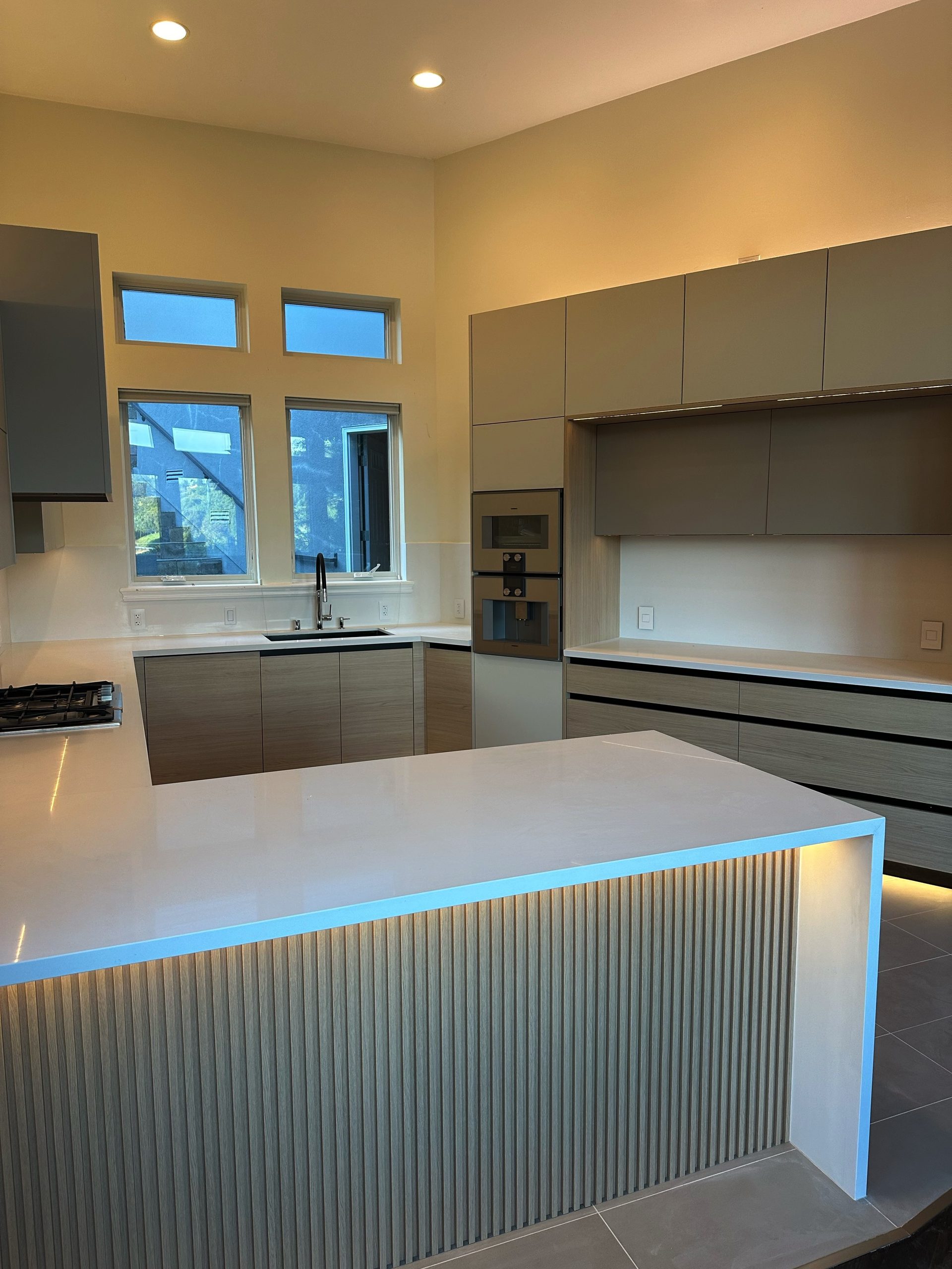 Primary finished-room view of light oak kitchen with integrated lighting cabinetry and surrounding surfaces