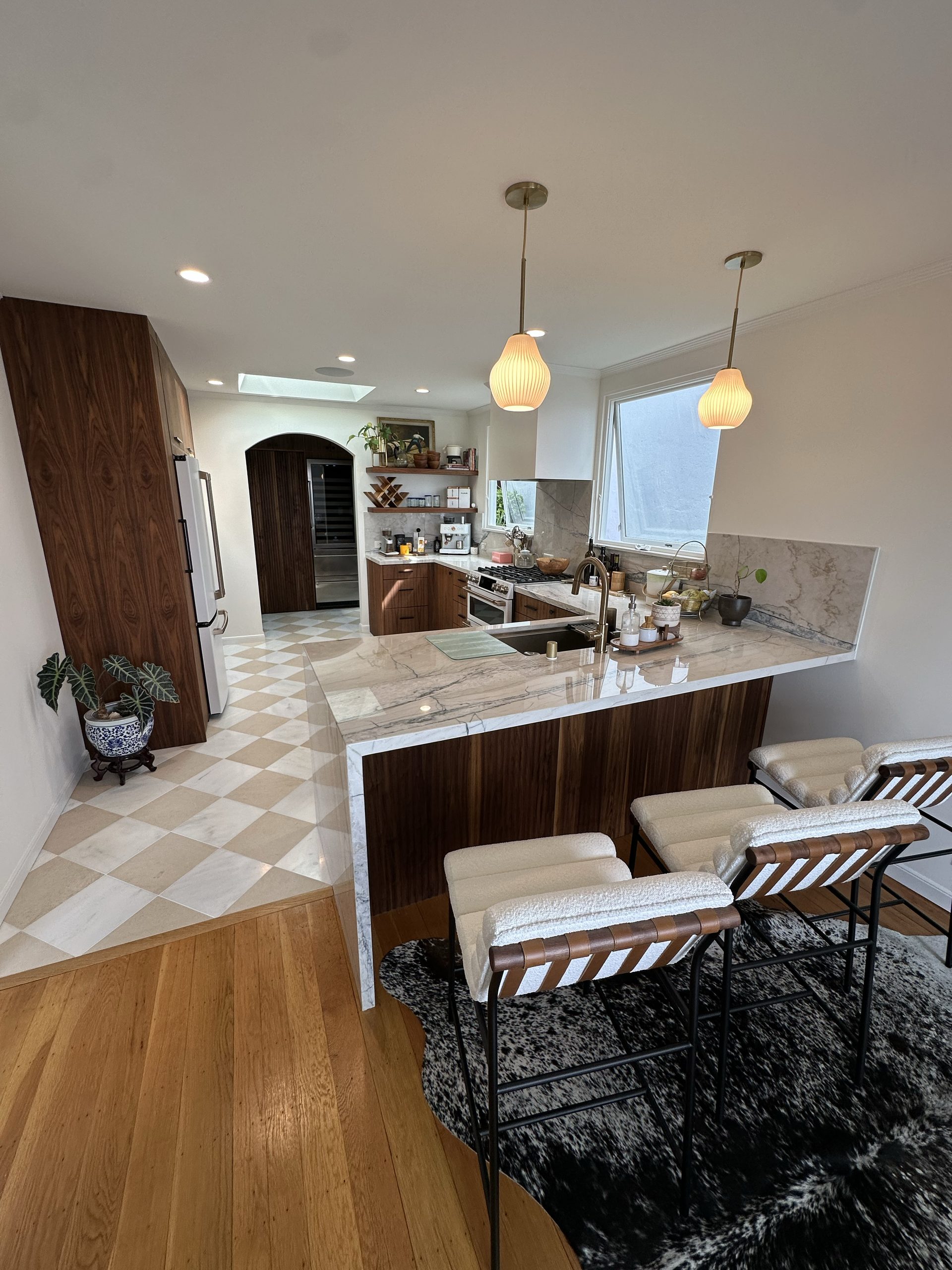 Primary finished-room view of walnut kitchen & tall storage cabinetry and surrounding surfaces